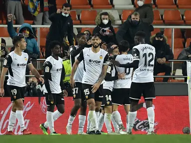 Para pemain Valencia merayakan gol yang dicetak penyerang Goncalo Guedes ke gawang Sevilla pada pertandingan lanjutan La Liga Spanyol di stadion Mestalla di Valencia (20/1/2022). Valencia bermain imbang atas Sevilla 1-1. (AFP/Jose Jordan)