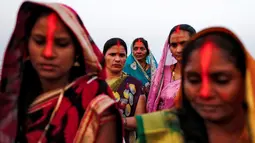 Sejumlah wanita melakukan ritual saat mengikuti festival keagamaan Chhat Puja di Mumbai, India (6/11). Ritual ini bentuk terima kasih mereka kepada Dewa Matahari  yang telah meberikan kehidupan. (Reuters/Danish Siddiqui)