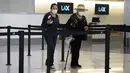 <p>Pelancong memakai masker di loket tiket di Bandara Internasional Los Angeles, Senin (25/4/2022). Seminggu sebelumnya, seorang hakim federal di Florida menolak persyaratan untuk memakai masker di bandara dan selama penerbangan. Aturan itu, yang dirancang untuk membatasi penyebaran COVID-19, akan berakhir pada 3 Mei. (AP Photo/Marcio Jose Sanchez)</p>