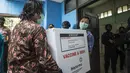 Pekerja menurunkan vaksin COVID-19 produksi Sinovac dari truk pengawalan polisi di Surabaya pada Senin (4/1/2021).  Pemerintah mulai mendistribusikan 3 juta dosis vaksin Covid-19 asal perusahaan China, Sinovac, ke 34 provinsi Indonesia. (Photo by Juni Kriswanto / AFP)