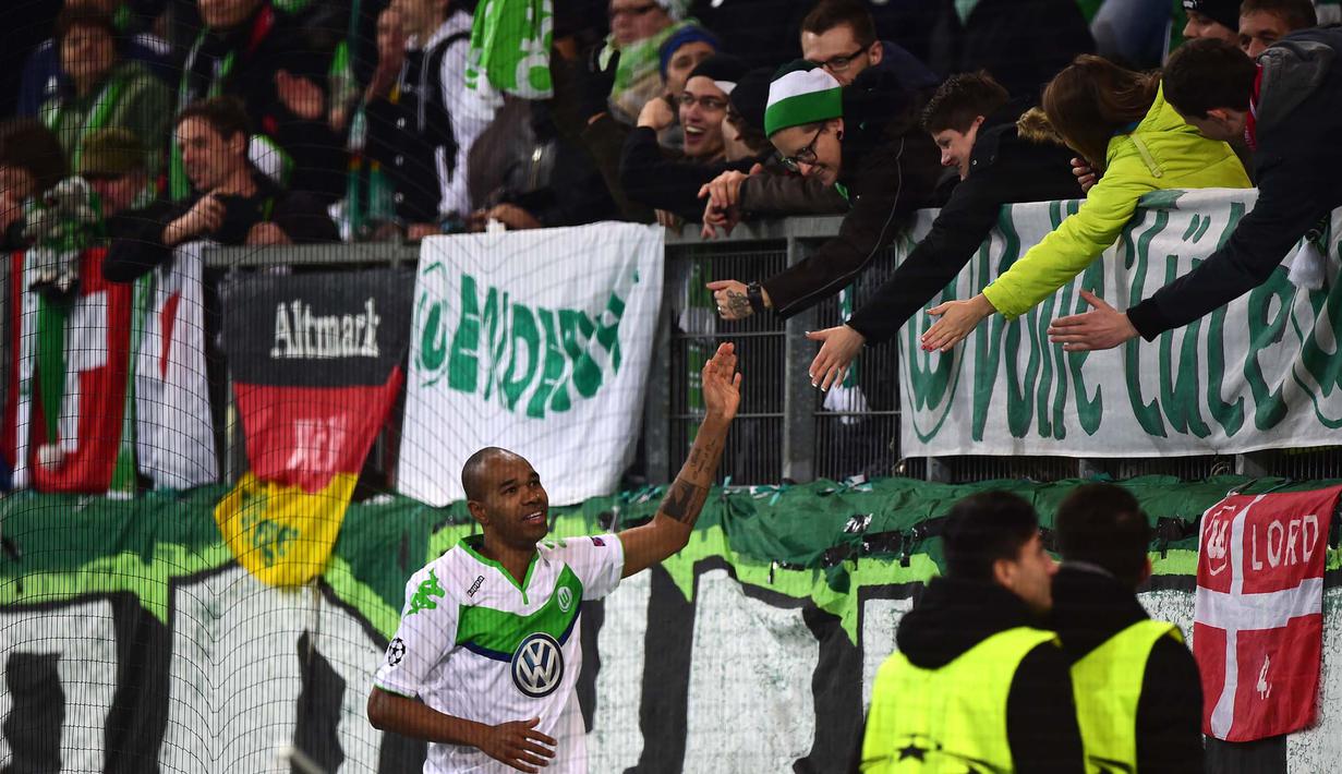 Pemain Wolfsburg, Naldo merayakan golnya ke gawang Manchester United bersama suporter pada lanjutan Liga Champions di Stadion VfL Woslfsburg Arena, Rabu (9/12/2015) dini hari WIB. (AFP Photo/John Macdougall)