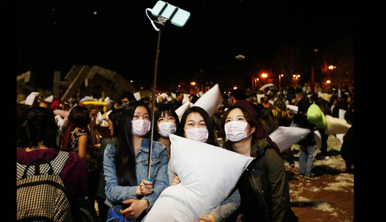 Sejumlah peserta berpose menggunakan tongsis saat ikut memeriahkan perayaan Hari Valentine dengan Perang Bantal di Justine Herman Plaza, San Francisco, Amerika Serikat, (14/2/2015). (REUTERS/Stephen Lam)
