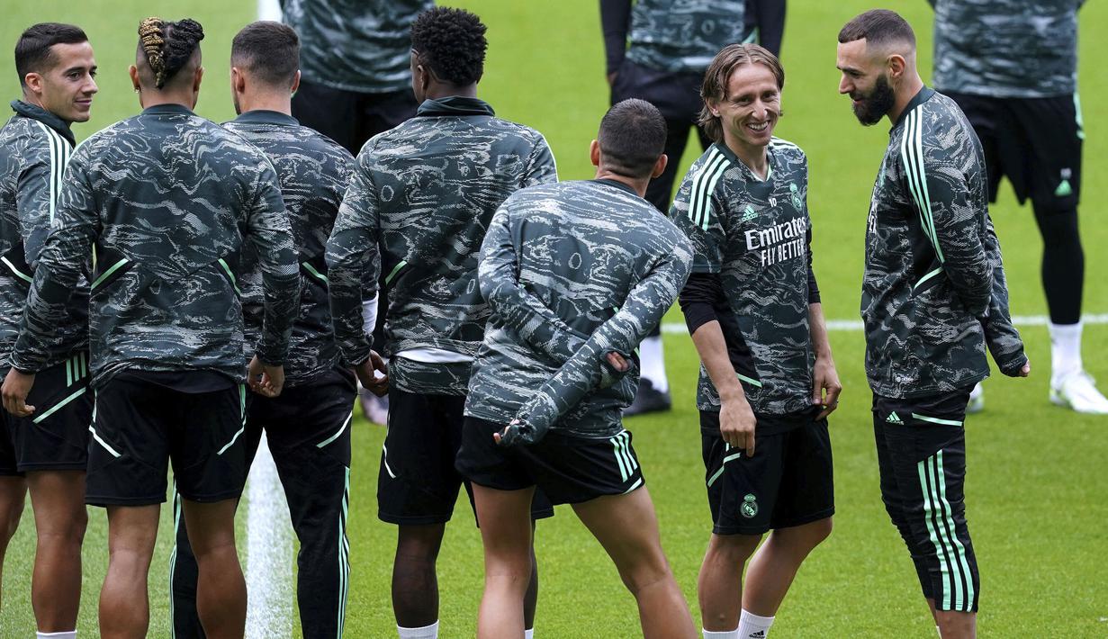 Pemain Real Madrid, Luka Modric bercengkrama dengan rekannya, Karim Benzema saat melakukan latihan menjelang laga semifinal Liga Champions 2022/2023 melawan Manchester City di Etihad Stadium, Manchester, Selasa (16/05/2023) waktu setempat. (AP Photo/PA/Martin Rickett)