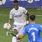 Winger Real Madrid Vinicius Junior coba menaklukkan kiper Huesca Alvaro Fernandez pada laga Liga Spanyol di Estadio El Alcoraz, Sabtu (6/2/2021). (AP Photo/Alvaro Barrientos)