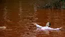 Orang-orang mandi dalam kolam warna merah untuk menandakan darah selama protes di depan kedubes Rusia di Vilnius, Lithuania, Kamis (7/4/2022). Pejabat Ukraina mengatakan 410 jasad warga sipil ditemukan di kota-kota wilayah Kiev yang baru-baru ini direbut kembali. (AP Photo/Mindaugas Kulbis)