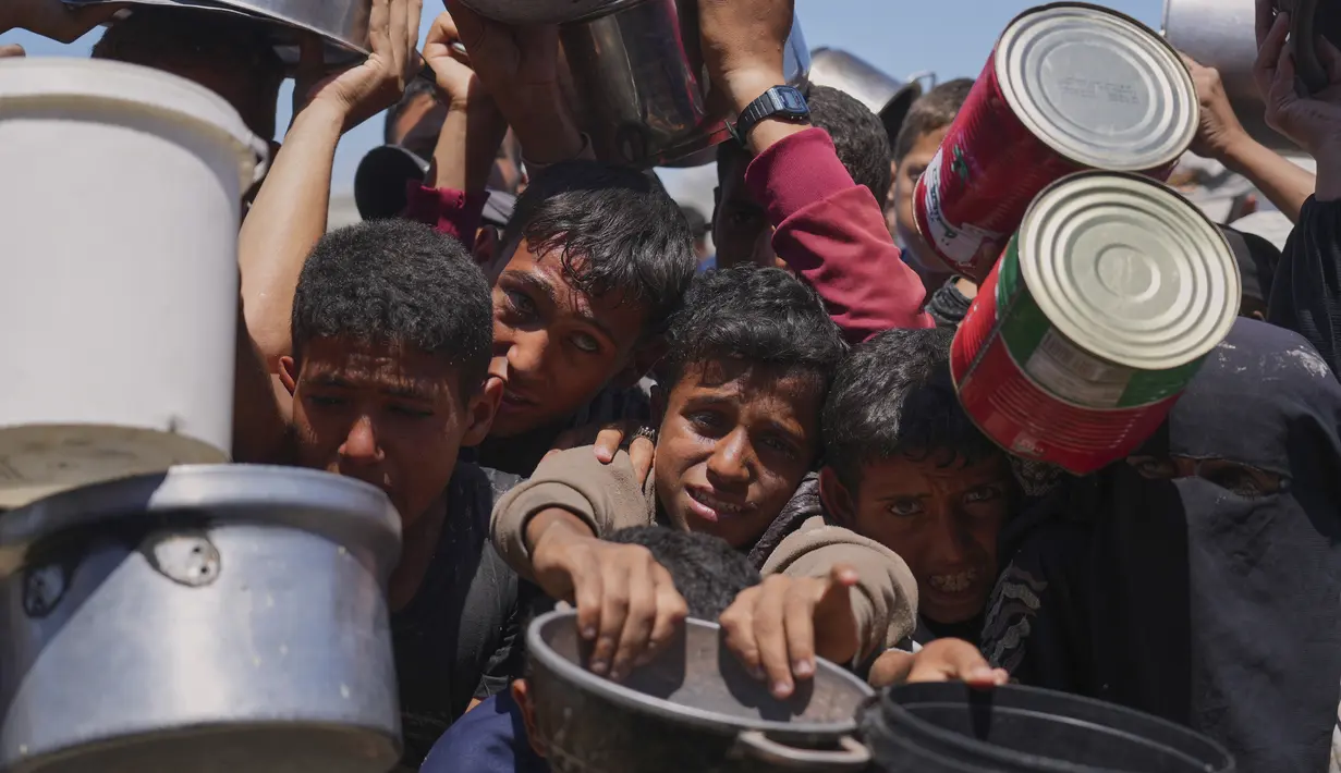 Warga Palestina berebut untuk mendapat pembagian makanan di sebuah dapur umum, Khan Younis, Jalur Gaza selatan, Senin 2 Juni 2025. (AP Photo/Abdel Kareem Hana)