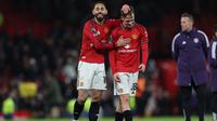 Striker Manchester United asal Brasil bernomor punggung 10, Matheus Cunha (kiri), dan gelandang Manchester United asal Inggris bernomor punggung 38, Jack Fletcher (kanan), merayakan kemenangan di lapangan setelah pertandingan Liga Inggris antara Manchester United dan Newcastle United di Old Trafford, Manchester, barat laut Inggris, Sabtu (27-12-2025) dini hari WIB. Man Utd memenangkan pertandingan dengan skor 1-0. (Darren Staples/AFP)