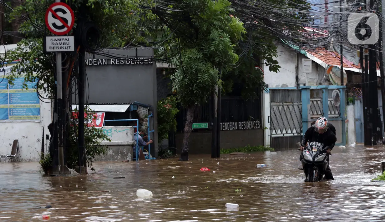 Pengendara menaiki sepeda motornya melewati banjir yang menggenangi kawasan Jalan Wolter Monginsidi Jakarta dan sekitarnya, Sabtu (20/2/2021). Hujan yang mengguyur Jakarta sejak Jumat (19/2) membuat sejumlah titik di Jakarta terendam banjir. (Liputan6.com/Helmi Fithriansyah)