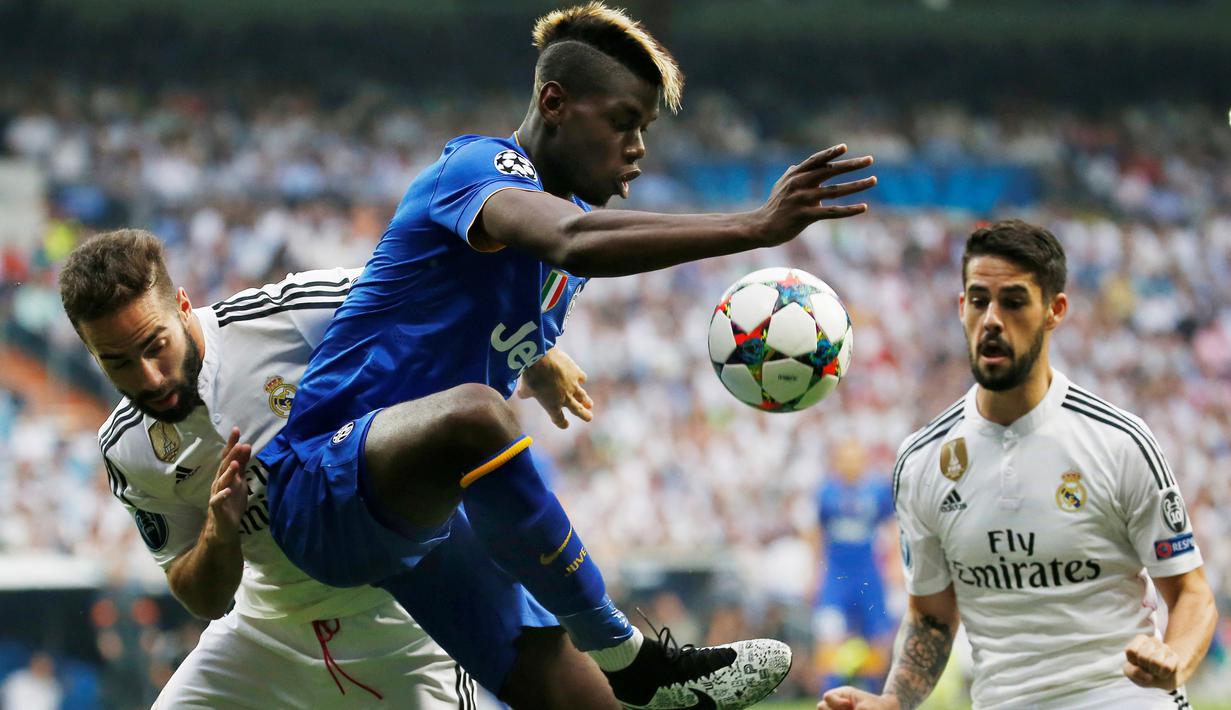 Paul Pogba (tengah) berebut bola dengan Dani Carvajal dan Isco. (Reuters / Paul Hanna)