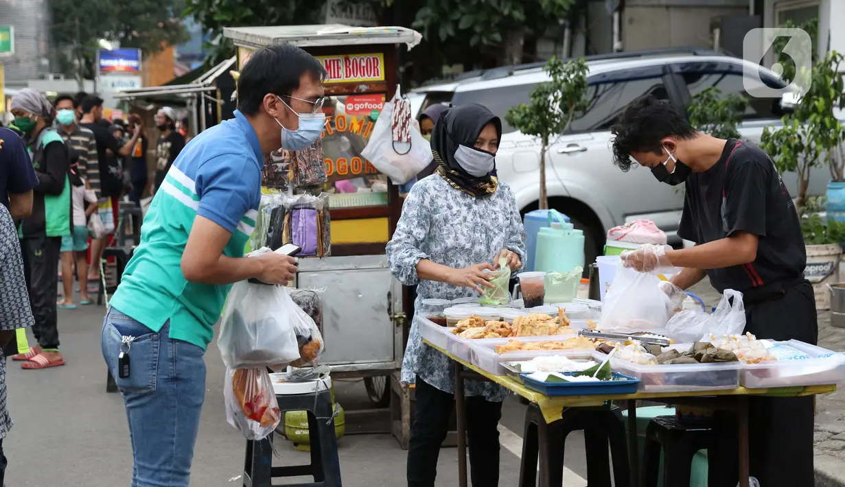 Aktivitas jual beli makanan untuk berbuka puasa di kawasan Bendungan Hilir, Jakarta, Sabtu (25/4/2020). Meski ditengah pandemi virus Covid-19, masyarakat masih antusias berburu penganan berbuka puasa dengan tetap menerapkan pola jaga jarak dan memakai masker. (Liputan6.com/Helmi Fithriansyah)