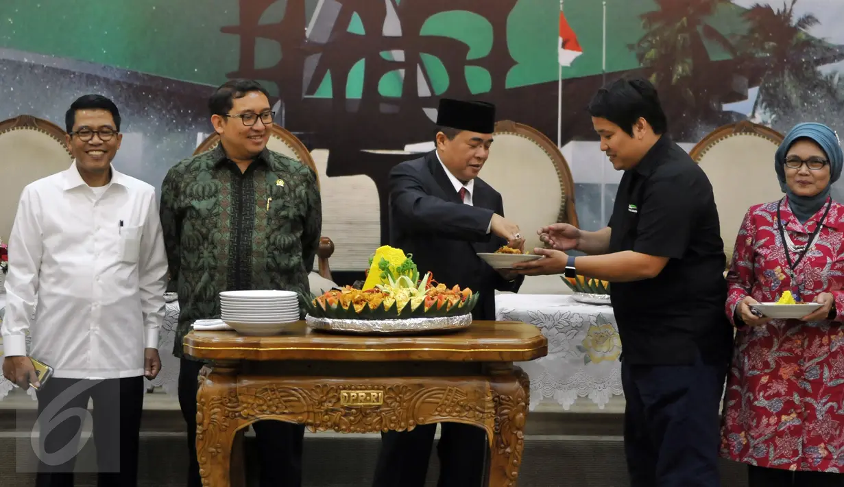 Ketua DPR Ade Komarudin (tengah) memberikan potongan tumpeng pertama kepada Ketua Pressroom DPR, Hilman (kedua kanan) saat meresmikan ruangan wartawan parlemen di Gedung Nusantara III kompleks parlemen, Jakarta, Selasa (5/4). (Liputan6.com/Johan Tallo)