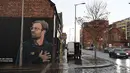 Kendaraan melintas dekat mural pelatih klub Liverpool, Jurgen Klopp di Jamaica Street, pusat kota Baltic Triangle di Liverpool, Senin (10/12). Pengerjaan mural tersebut dimulai sejak Sabtu, 8 November lalu oleh seniman jalanan "Akse". (Paul ELLIS / AFP)