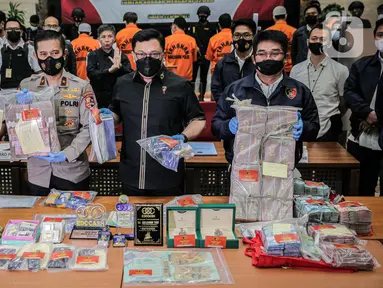 Dirtipideksus Bareskrim Polri Brigjen Pol Helmy Santika dan Karopenmas Divisi Humas Polri menunjukkan barang bukti saat rilis kasus dugaan investasi ilegal E-Dinar Coin (EDC) Cash.di Bareskrim Polri, Jakarta, Kamis (22/4/2021). (Liputan6.com/Faizal Fanani)