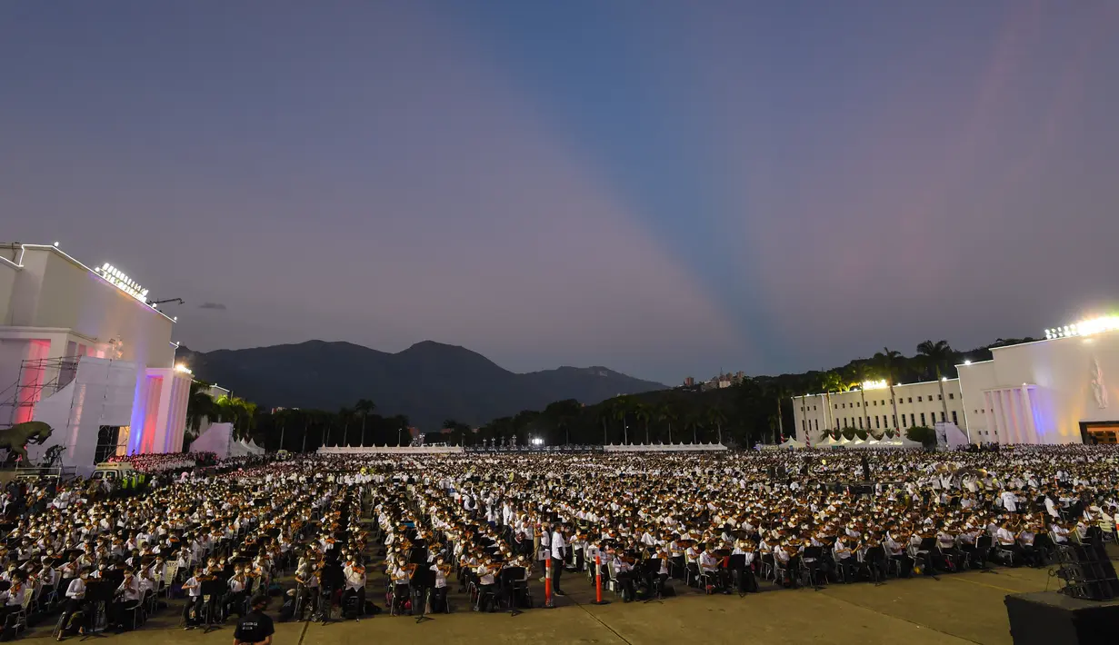 Musisi dari National System of Orchestras of Venezuela berusaha memecahkan rekor dunia bermain orkestra terbesar di dunia, di Caracas pada 13 November 2021. Rekor konser terbesar saat ini masih dipegang oleh Rusia sejak 2019 dengan peserta 8.097 musisi. (Federico PARRA/AFP)