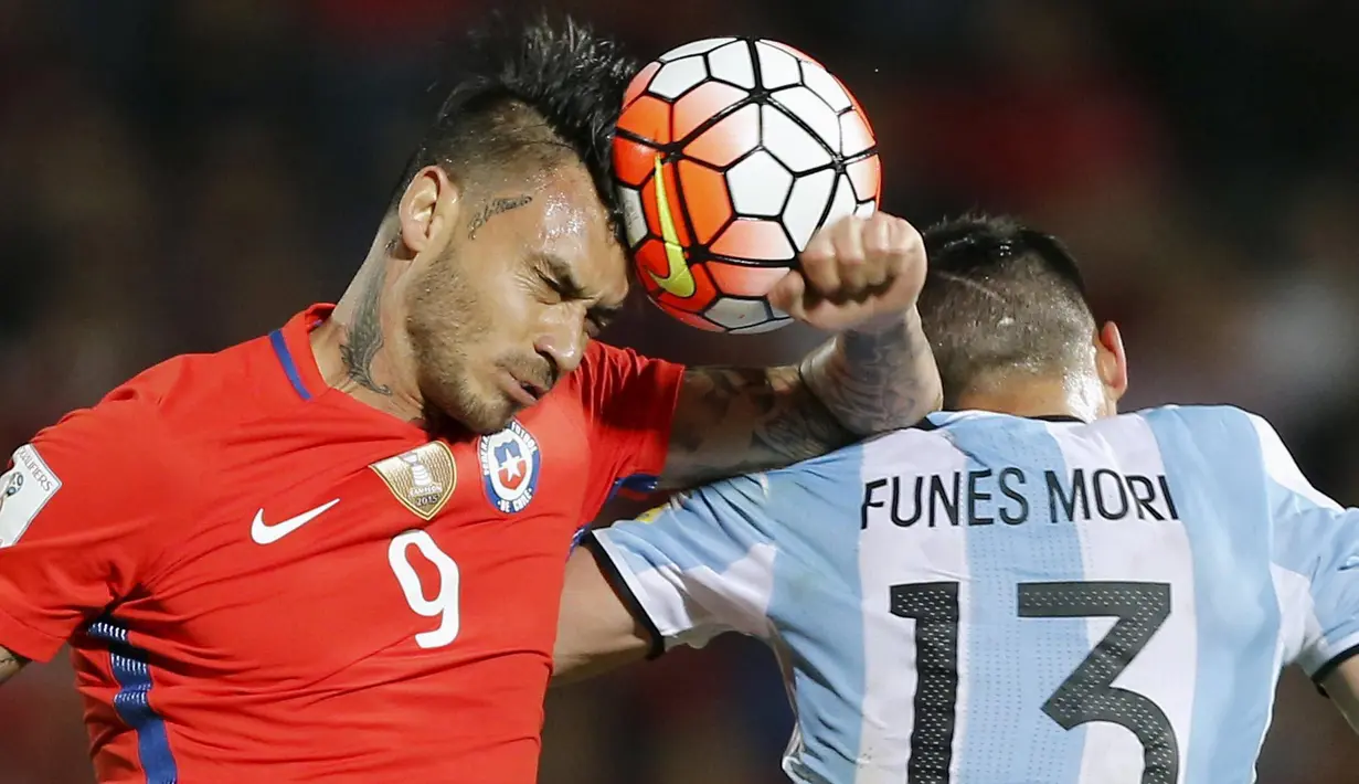 Pemain Argentina, Ramiro Funes Mori (kanan) berebut bola dengan pemain Cile, Mauricio Pinilla pada laga kualifikasi Piala Dunia 2018 zona CONMEBOL di Stadio Nacional Julio Martinez Pradanos, Santiago, Jumat (25/3/2016) pagi WIB.  (REUTERS/Rodrigo Garrido)