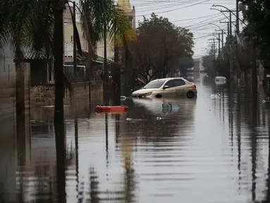 Sebuah mobil terendam sebagian di jalan yang tergenang banjir di lingkungan Sarandi, salah satu daerah yang paling parah dilanda hujan lebat di Porto Alegre, negara bagian Rio Grande do Sul, Brasil, pada tanggal 27 Mei 2024. (Anselmo Cunha/AFP)