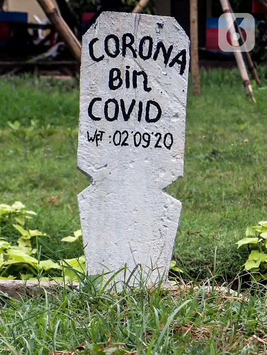 Papan nisan bertuliskan Corona bin Covid di taman Jalan Jatinegara Barat, Jakarta, Minggu (20/9/2020). Kuburan tersebut sengaja dibuat untuk mengingatkan masyarakat yang melintas akan bahaya virus Covid-19. (Liputan6.comm/Johan Tallo)