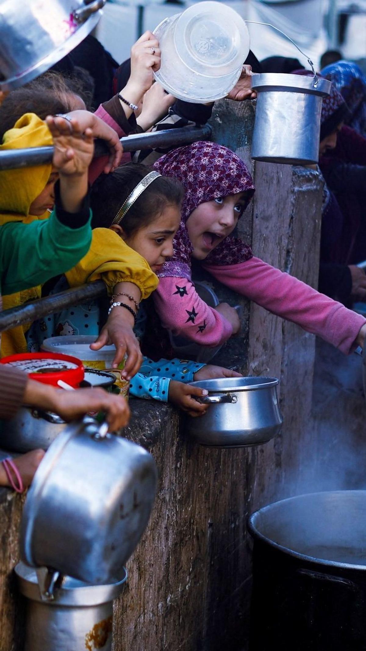 Setiap hari mereka harus berdesakan seperti ini demi sepanci kecil makanan gratis dari bantuan lembaga kemanusiaan tersebut.&nbsp;Foto: REUTERS / Mohammed Salem