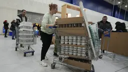 Orang-orang membawa pembelian mereka saat toko IKEA tutup di pinggiran St. Petersburg, Kamis (3/3/2022). Peritel IKEA menghentikan operasional di "Negeri Beruang Merah" dan Belarusia untuk sementara waktu mulai Jumat, 4 Maret 2022 buntut dari invasi Rusia ke Ukraina. (AP Photo/Dmitri Lovetsky)