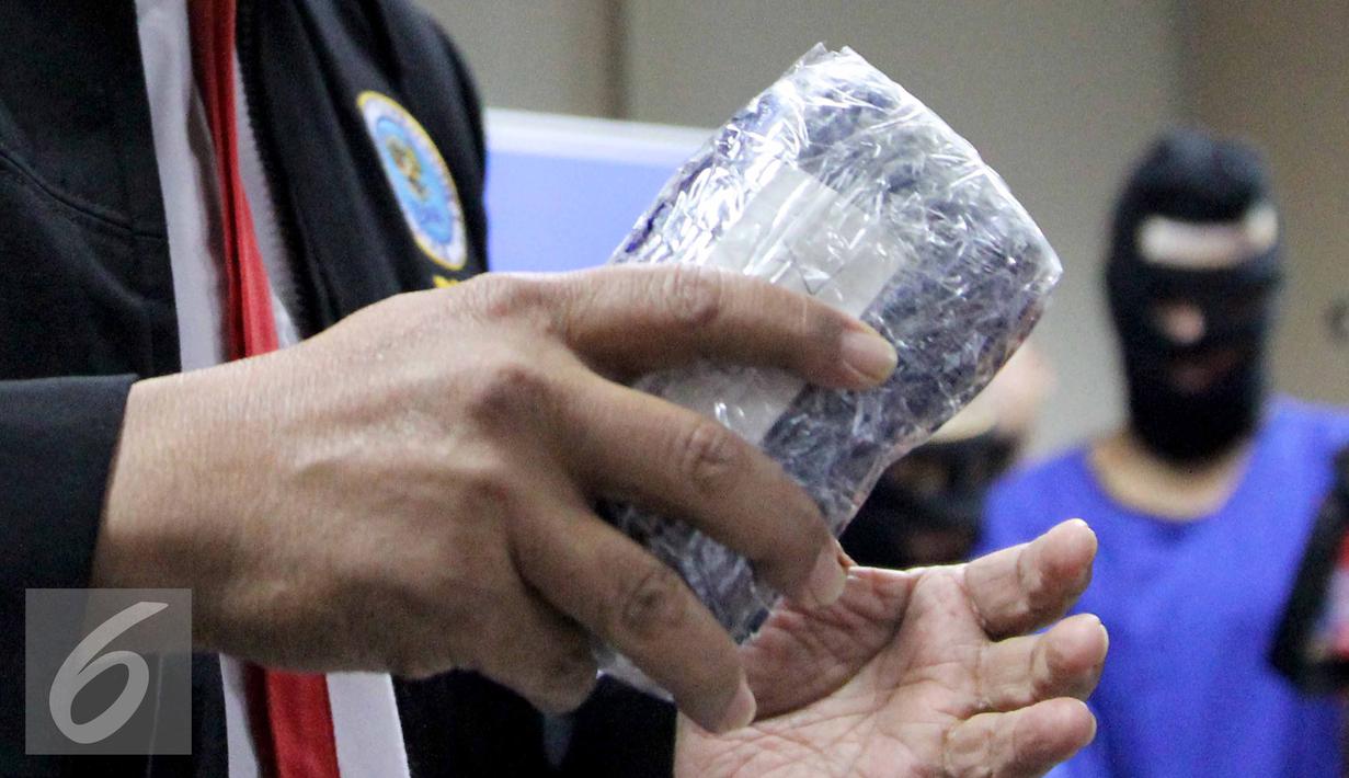 Petugas BNN memperlihatkan Sabu yang telah dikemas saat rilis narkoba di Kantor BNN, Jakarta, Rabu (8/7/2015). BNN amankan dua perempuan dan Sabu sebanyak 10,392,9 gram. (Liputan6.com/Helmi Afandi)