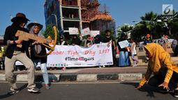 Sejumlah massa yang tergabung dalam forum harimaukita menggelar aksi teatrikal saat mengkampanyekan Global Tiger Day di Bundaran HI, Jakarta, Minggu (30/7). Acara ini untuk memperingati Tiger Day yang jatuh setiap tgl 29 Juli. (Liputan6.com/Helmi Afandi)