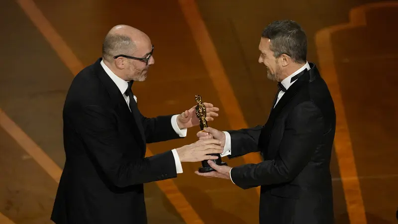 Edward Berger penulis naskah All Quiet on the Western Front menerima Piala Oscar dari Antonio Banderas di ajang Oscar 2023. (Foto: AP Photo/Chris Pizzello)