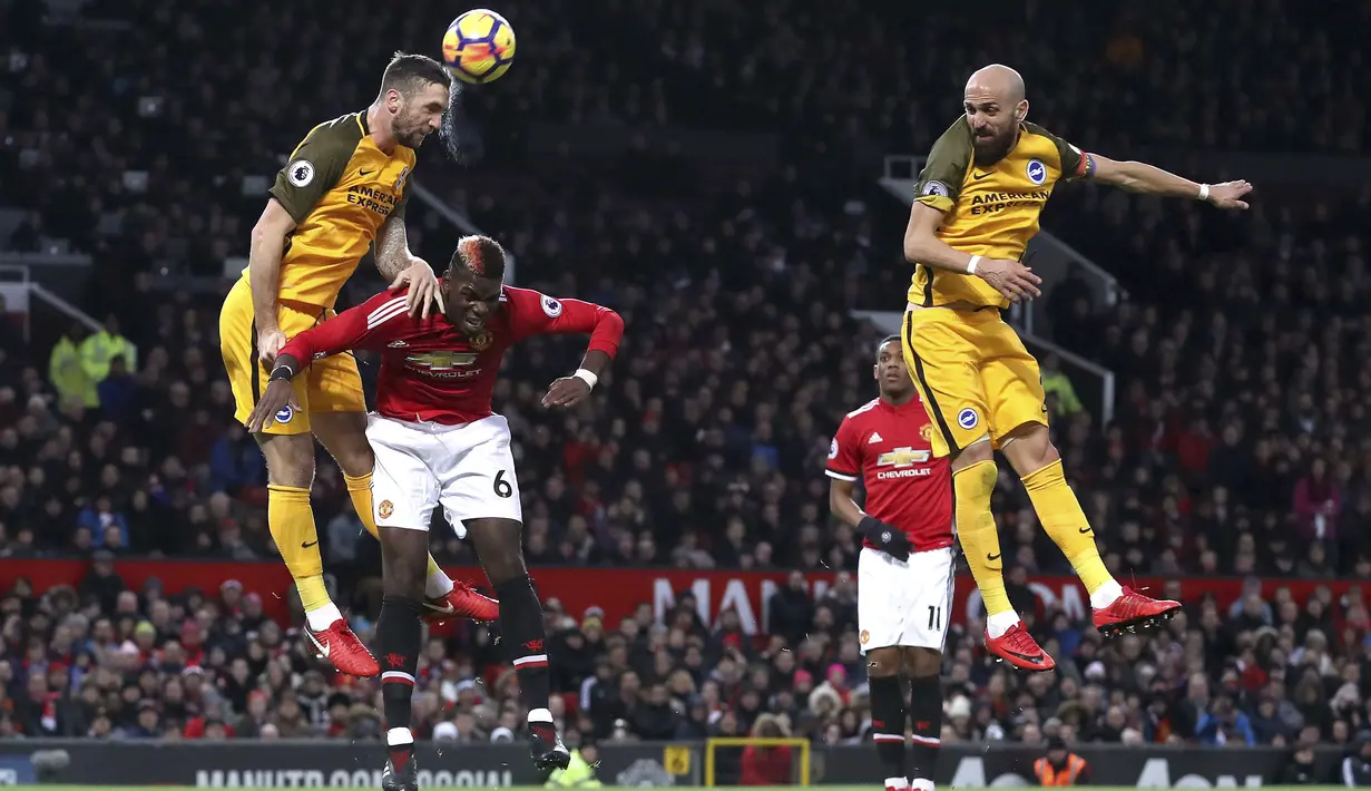 Duel pemain Brighton & Hove Albion, Shane Duffy (kiri) dan pemain Manchester United, Paul Pogba pada lanjutan Premier League di Old Trafford, Manchester,(25/11/2017). Manchester United menang tipis 1-0. (Martin Rickett/PA via AP)