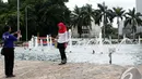 Seorang pengunjung mengabadikan gambarnya di Bundaran Hotel Indonesia (HI), Jakarta, Kamis (1/1/2015). (Liputan6.com/Faizal Fanani)