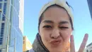 Berlatar langit biru, Gracia Indri selfie mengenakan wool coat berwarna abu-abu yang dipadukan dengan syal dari Gucci. Ia juga mengenakan aksesori puffy bandana berwarna putih (instagram/graciaz14)