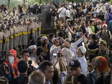 Peserta aksi massa Gerakan Nasional Kedaulatan Rakyat membuat barikade jelang membubarkan diri usai unjuk rasa di depan Gedung Bawaslu, Jakarta, Selasa (21/5/2019). Mereka meminta Bawaslu memeriksa hasil suara Pemilu 2019 yang dinilai banyak kecurangan. (Liputan6.com/Helmi Fithriansyah)
