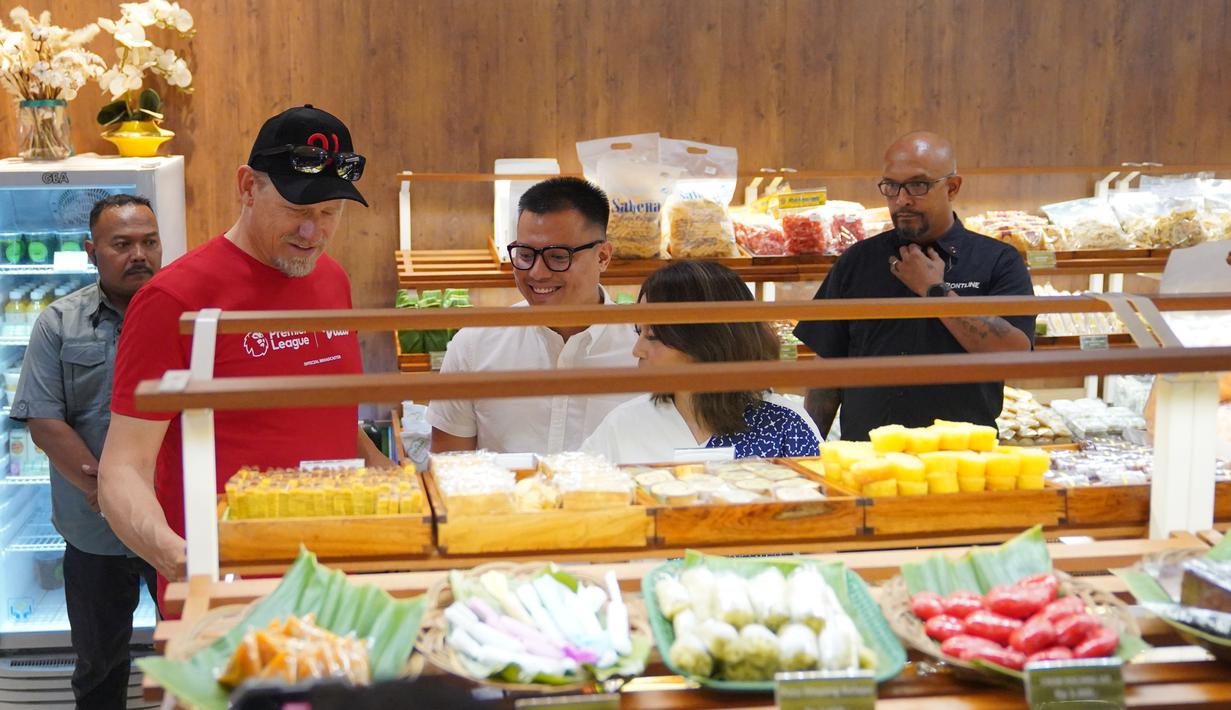 <p>Pangeran Siahaan (tengah) dan Deasy Noviyanti (kanan) mengenalkan berbagai macam jajanan pasar ke Peter Schmeichel saat mengunjungi pusat perbelanjaan Sarinah, Jumat (4/8/2023). (Dok. Vidio)</p>