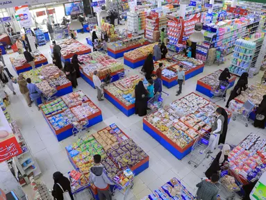 Warga Yaman membeli permen dan kacang-kacangan saat umat Islam bersiap untuk merayakan liburan tahunan Idul Adha (Hari Raya Kurban) di supermarket di ibu kota Sanaa (18/7/2021). (AFP/Mohammed Huwais)