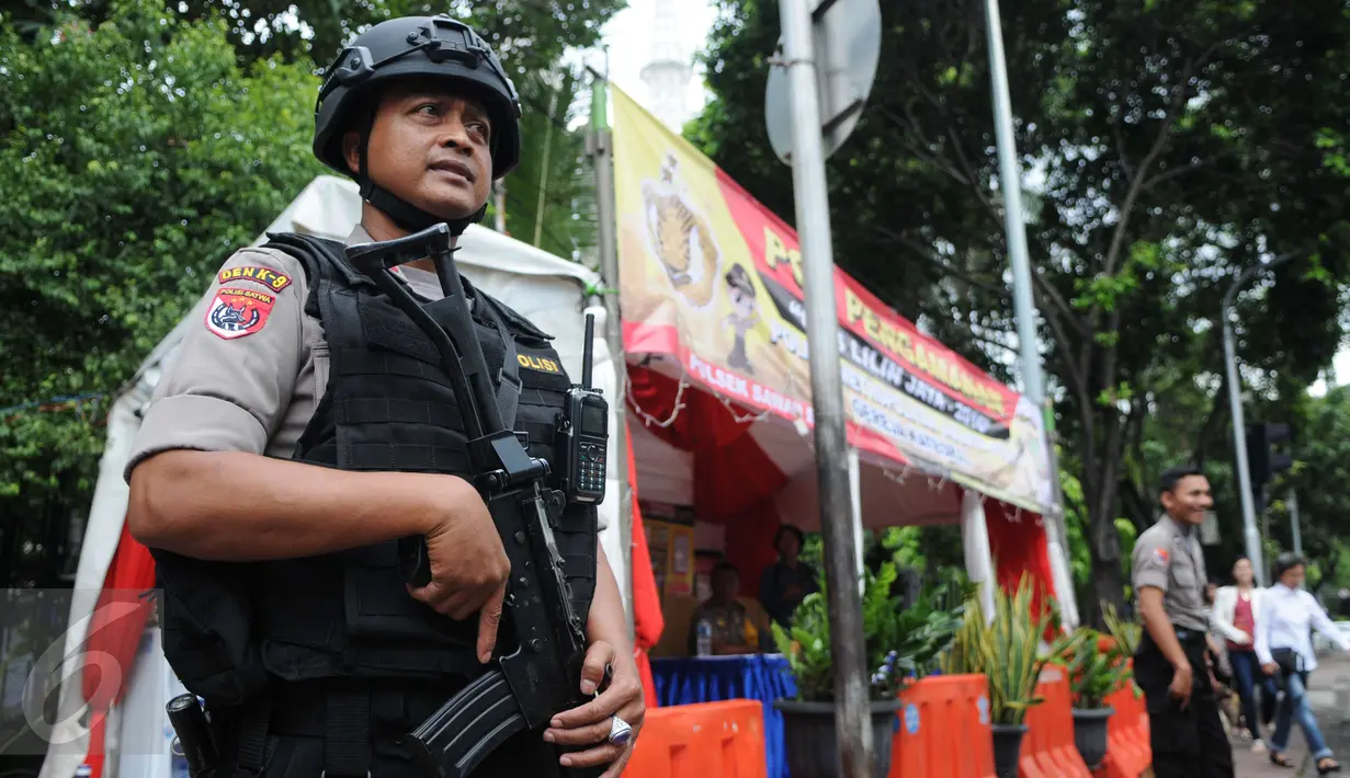 Petugas kepolisian berjaga di depan Gereja Katedral, Jakarta, Sabtu (24/12). Penjagaan dilakukan untuk menjaga kondusifitas agar acara Malam Misa Natal bisa berjalan lancar. (Liputan6.com/Helmi Afandi) 