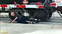 Seorang pria terekam nekat berguling di bawah kereta barang yang sedang berjalan. Jangan ditiru.