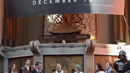 Pasangan Caroline Ritter dan Andrew Porters saat upacara pernikahan bertema Star Wars: The Force Awakens di depan gedung bioskop di Hollywood, Los Angeles,  Kamis (17/12). Pemimpin upacara pernikahan pun mengenakan jubah sang Jedi. (dailymail.co.uk)
