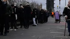 Orang-orang antre untuk suntikan vaksin booster Covid-19 di Rumah Sakit St Thomas, London, Senin (13/12/2021). Antrean panjang terbentuk di pusat vaksinasi di Inggris ketika pemerintah mendorong agar semua orang dewasa mendapatkan vaksin booster untuk cegah penyebaran Omicron. (AP Photo/Matt Dunham)