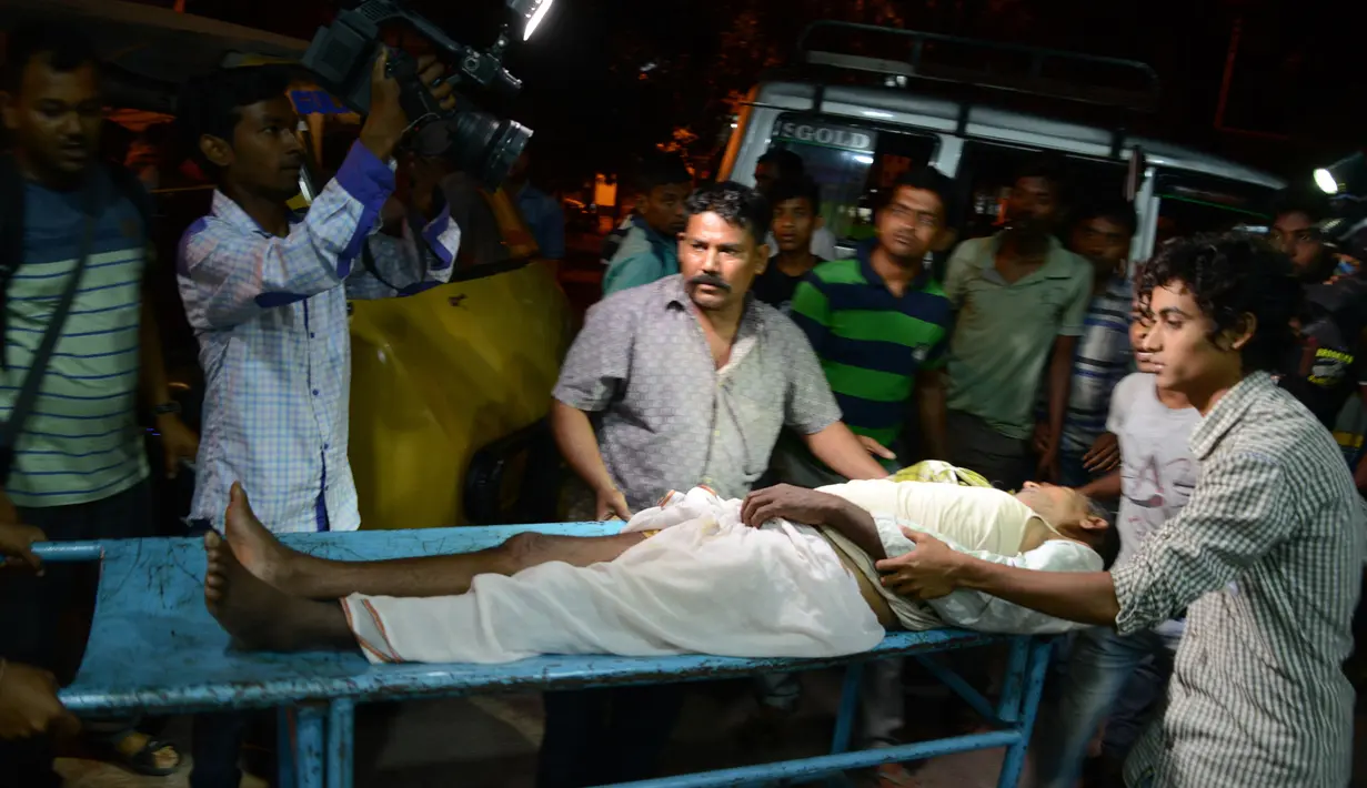 Pegawai Rumah Sakit Siliguri membantu korban luka saat gempa di Siliguri, India, Rabu (13/4). Gempa berkekuatan 6,9 SR melanda Myanmar dan guncangan dirasakan di beberapa bagian China dan India. (Diptendu DUTTA/AFP)