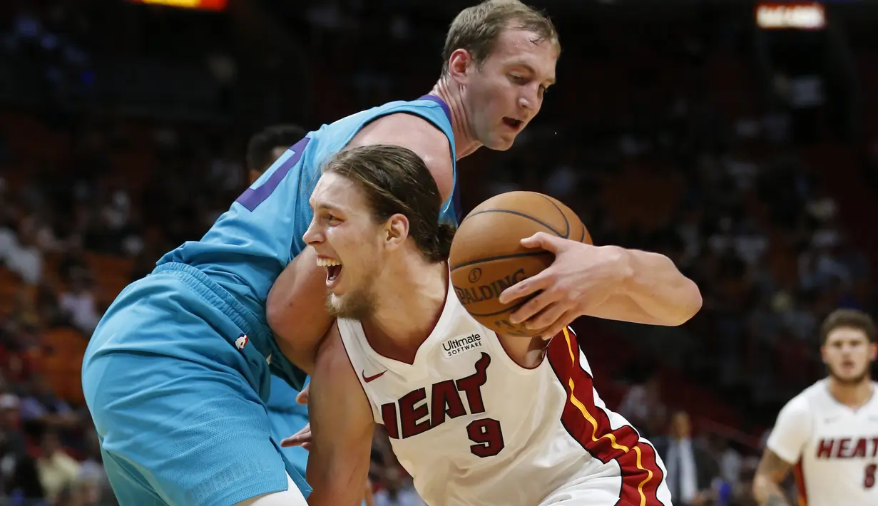 Aksi pebasket Miami Heat, Kelly Olynyk #9 menggiring bola melewati adangan pebasket Hornets, Cody Zeller #40 pada laga NBA pre-season di American Airlines Arena, Miami, (9/10/2017). Miami Heat menang 109-106. (AP/Wilfredo Lee)