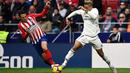 Bek Atletico Madrid, Santiago Arias berusaha merebut bola yang dibawa striker Real Madrid, Mariano selama pertandingan lanjutan La Liga Spanyol di stadion Wanda Metropolitano (9/2). Real Madrid menang 3-1 atas Atletico. (AFP Photo/Pierre-Philippe Marcou)