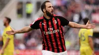 Striker AC Milan Gonzalo Higuain merayakan gol ke gawang Chievi Verona pada laga Serie A di San Siro, Minggu (7/10/2018). (AFP/Marco Bertorello)