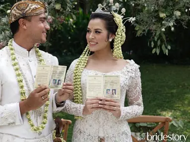Penyanyi Raisa dan Hamish Daud menunjukkan buku pernikahan usai melangsungkan akad nikah. Minggu 3 September 2017 menjadi hari terindah Raisa dan Hamish Daud. Mereka mengikat janji suci sehidup semati. (Instagram/thebridestory)
