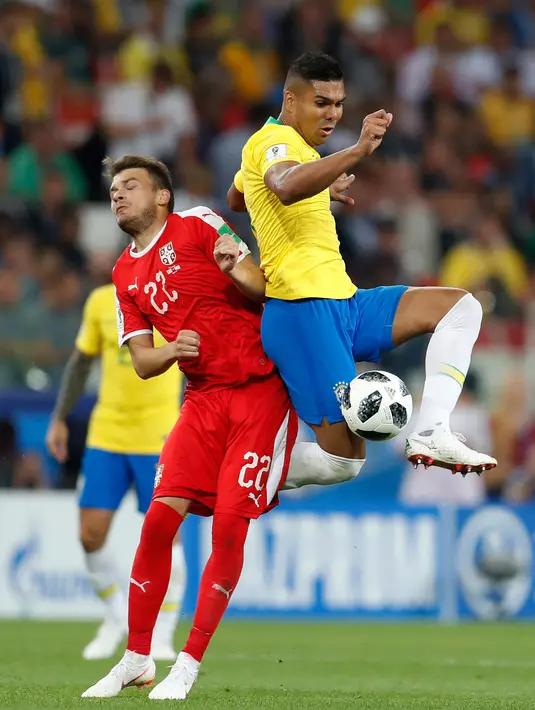Gelandang Brasil, Casemiro berebut bola dengan pemain Serbia Adem Ljajic saat bertanding pada grup E Piala Dunia 2018 di Stadion Spartak di Moskow, Rusia (27/6). Brasil menang 2-0 atas Serbia dan melaju ke babak 16 besar. (AP Photo/Rebecca Blackwell)