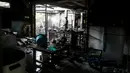 Seorang petugas forensik memeriksa bangunan asrama sekolah yang hangus terbakar di Thailand utara, Senin (23/5). 17 siswi tewas setelah kebakaran menghanguskan asrama sekolah untuk anak-anak suku pedalaman miskin itu. (REUTERS/Athit Perawongmetha)