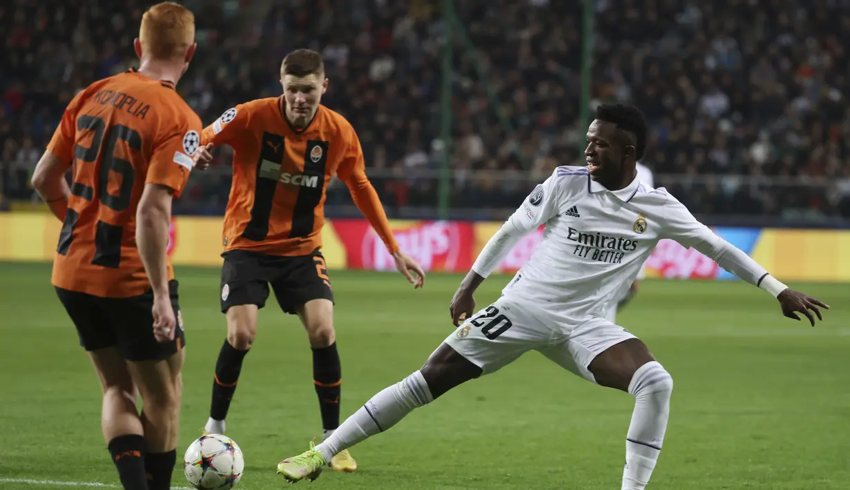 <p>Penyerang Real Madrid, Vinicius Junior berusaha menghalau bola umpan pemain Shakhtar Donetsk, Yukhym Konoplya pada pertandingan lanjutan grup F Liga Champions di stadion Polish Army Stadium di Warsawa, Polandia, Rabu, 12 Oktober 2022. Shakhtar Donetsk bermain imbang atas Real Madrid 1-1. (AP Photo/Michal Dyjuk )</p>