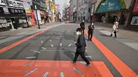 Pejalan kaki menggunakan masker di pusat belanja Dongseongro yang berlokasi di tenggara Kota Daegu pada Jumat, 21 Februari 2020. (dok. Foto JUNG YEON-JE / AFP)