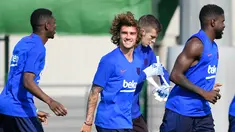 Penyerang baru Barcelona, Antoine Griezmann tertawa ketika melakukan pemanasan selama latihan pramusim pertama di Joan Gamper, Barcelona (15/7/2019). Griezmann resmi menjadi pemain Barcelona usai diboyong dari Atletico Madrid. (AFP Photo/Lluis Gene)