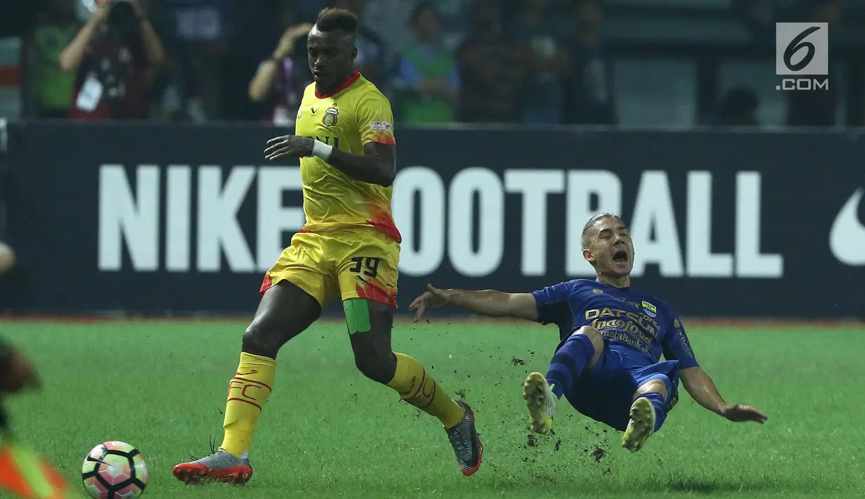 Pemain tengah Persib, Kim Jeffrey Kurniawan (kanan) terjatuih usai berebut bola dengan penyerang Bhayangkara FC Guy Junior dilanjutan Liga 1 di Stadion Patriot Candrabhaga, Bekasi, Minggu (4/6). Bhayangkara FC menang 2-0. (Liputan6.com/Helmi Fithriansyah)