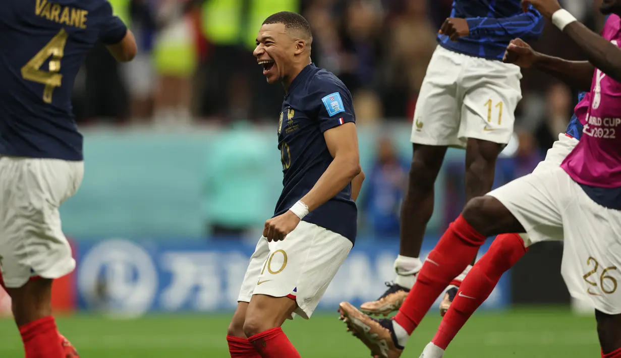 Penyerang #10 Prancis Kylian Mbappe merayakan kemenangan timnya atas Inggris dengan rekan setimnya pada akhir laga perempat final Piala Dunia 2022 di Al Bayt Stadium, Minggu (11/12/2022) dini hari WIB. Mbappe tampak merayakan gagalnya penalti Kane dan berteriak serta tertawa lepas.(Adrian DENNIS / AFP)