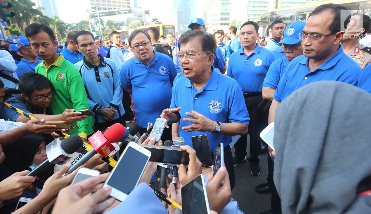 Wapres Jusuf Kalla memberi keterangan kepada awak media saat menghadiri kampanye tahun keselamatan untuk kejiwaaan 2017-2018 di Bundaran HI, Jakarta, Minggu (30/7). Dalam acara ini JK juga didampingi Menhub, Budi Karya Sumadi. (Liputan6.com/Helmi Afandi)