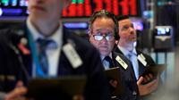 Steven Kaplan (tengah) saat bekerja dengan sesama pialang di New York Stock Exchange, Amerika Serikat, Rabu (11/3/2020). Bursa saham Wall Street anjlok karena investor menunggu langkah agresif pemerintah AS atas kejatuhan ekonomi akibat virus corona COVID-19. (AP Photo/Richard Drew)